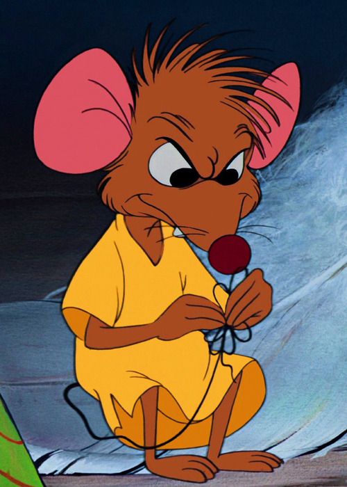 a cartoon mouse sitting on the ground holding a flower in its hand and looking at something