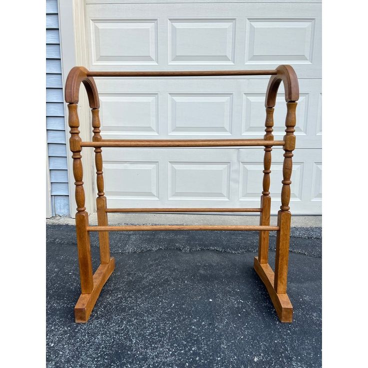 an old wooden bed frame in front of a garage door with the top rail missing