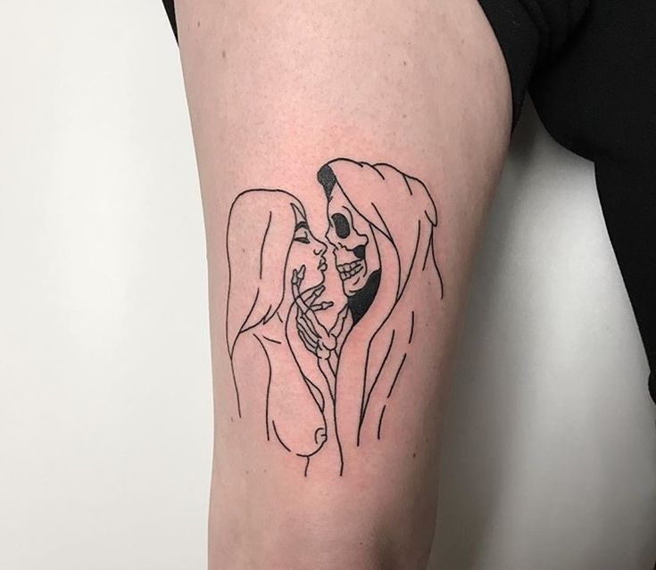 a woman's arm with a tattoo of a man kissing her on the cheek