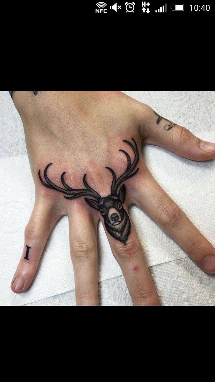 a hand with a tattoo on it that has a deer's head in the middle