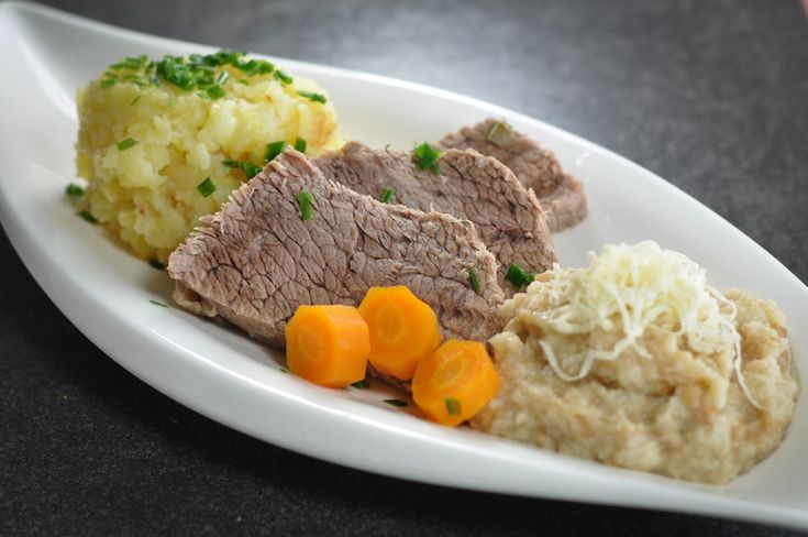 a white plate topped with meat, mashed potatoes and carrots