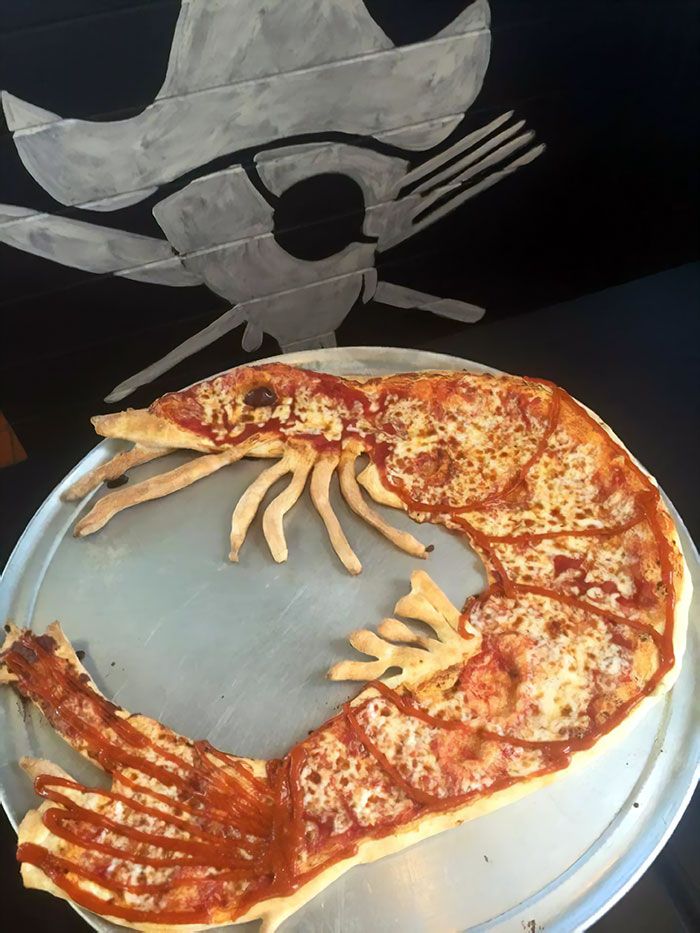 a pizza that is on top of a metal pan with some forks and knives in it