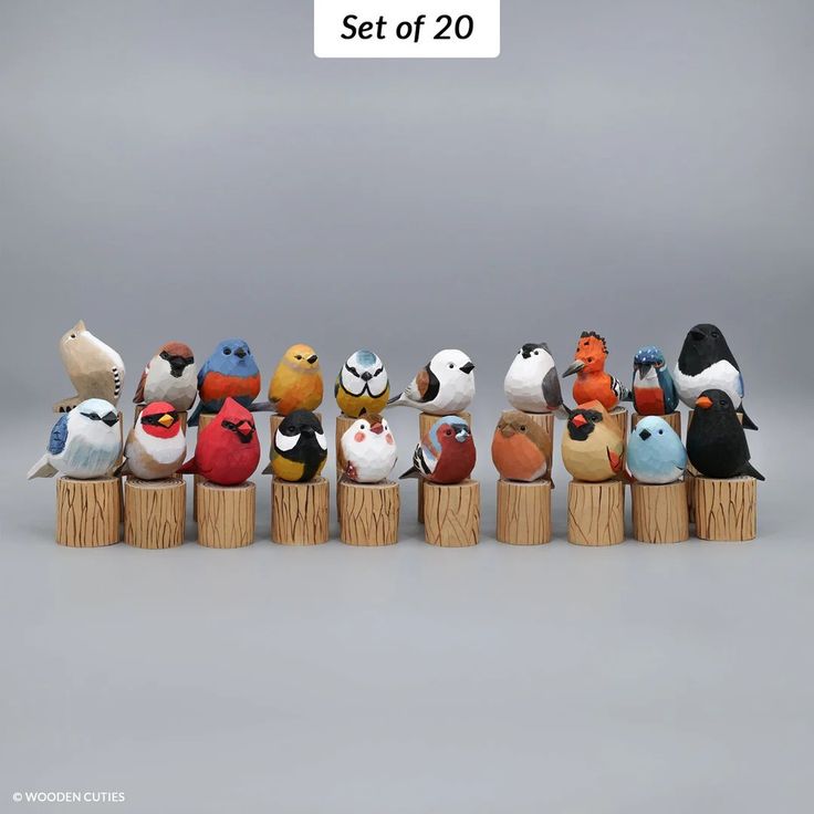 a group of stuffed birds sitting on top of wooden posts in front of a gray background