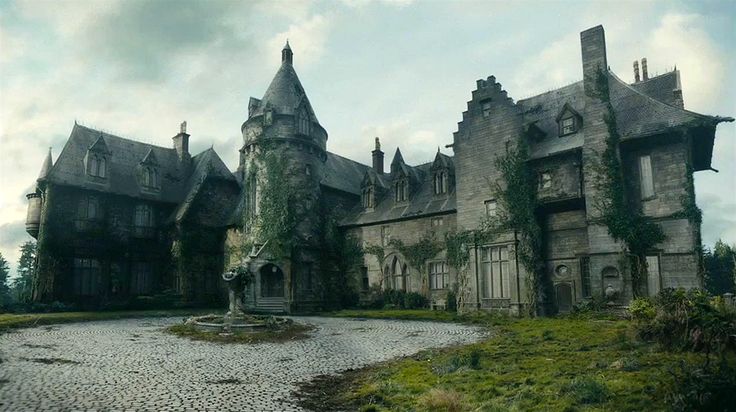 an old castle with ivy growing all over it's walls and roof, on a cloudy day