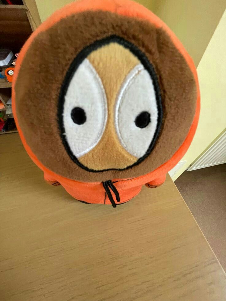 a brown and orange stuffed animal sitting on top of a wooden floor