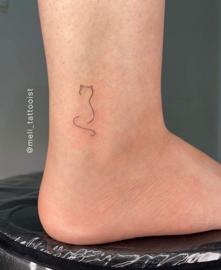 a small cat tattoo on the ankle