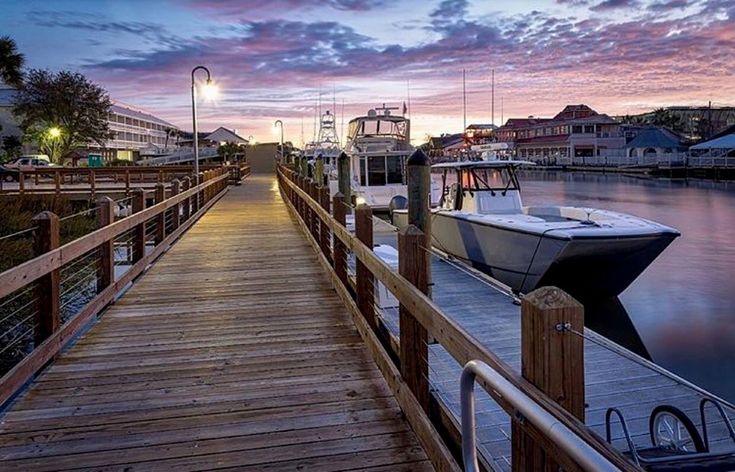 a boat docked at the end of a wooden dock