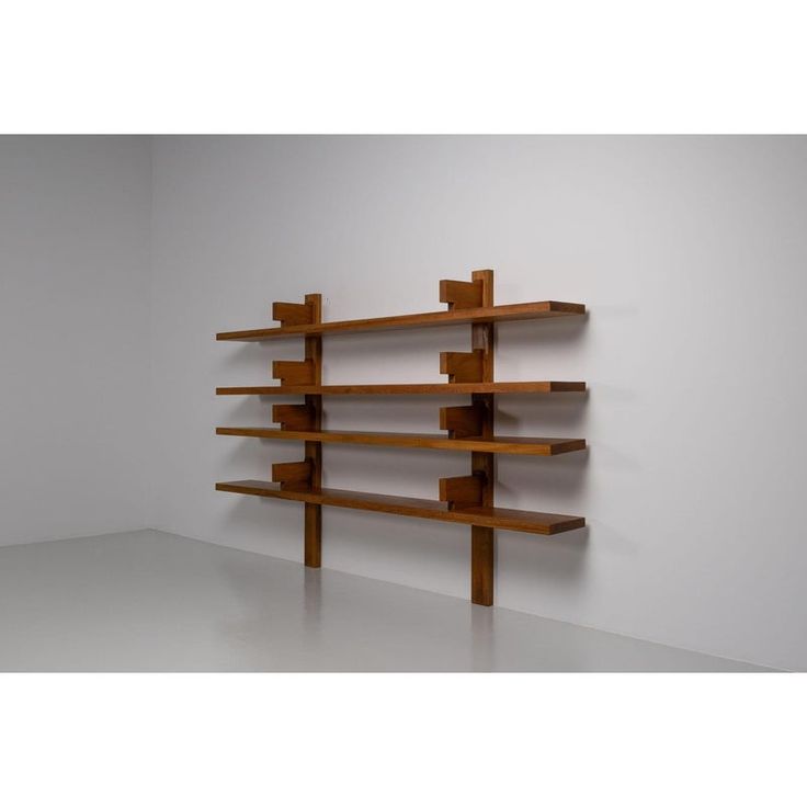 a wooden shelf sitting on top of a white floor next to a wall filled with shelves