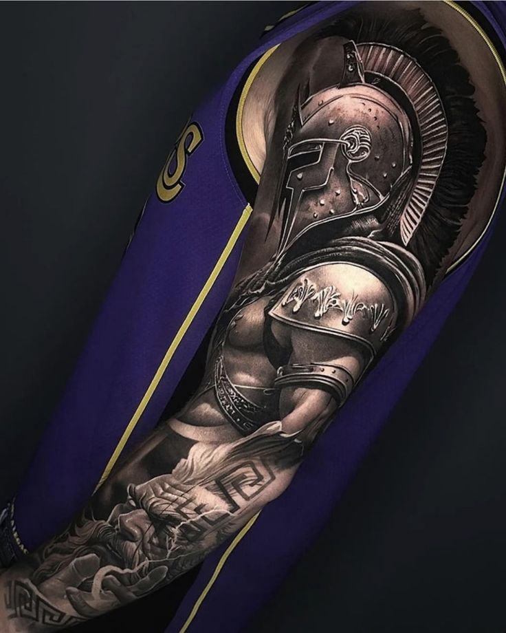 a man's arm with a roman soldier tattoo on it and an eagle above the helmet