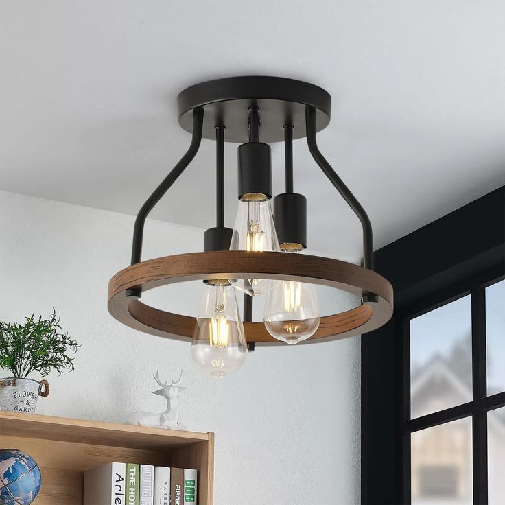 a wooden light fixture hanging from the ceiling in a room with bookshelves and windows