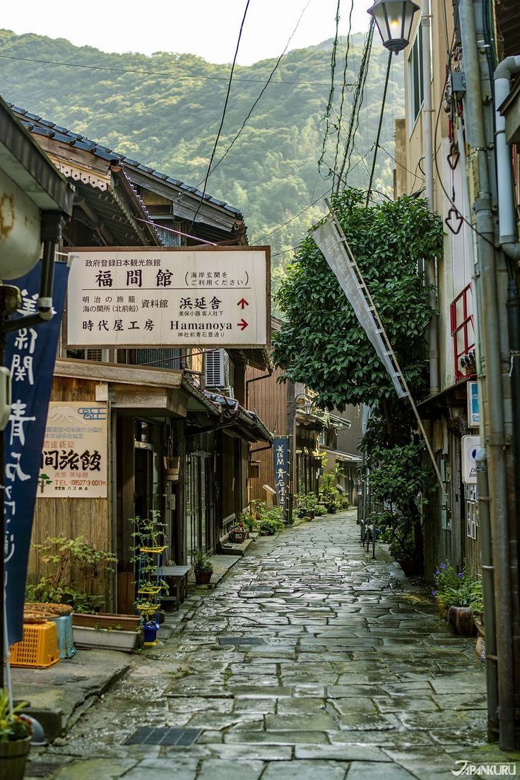 an alley way with signs on the buildings and trees in the backgrouds