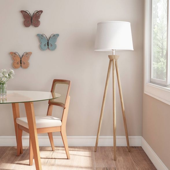 a room with a table, chair and lamp in it