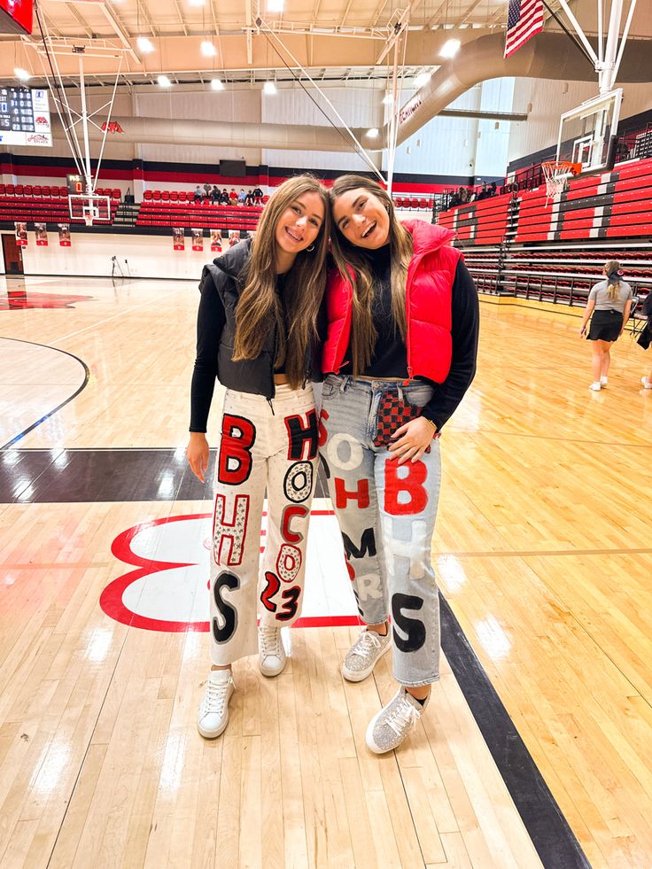 two women standing on a basketball court with their arms around each other