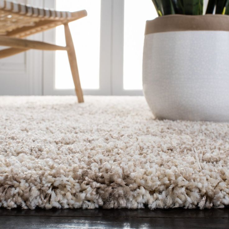 a white rug with a potted plant next to it