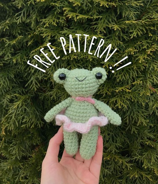 a hand holding a small crocheted frog with the words free pattern on it