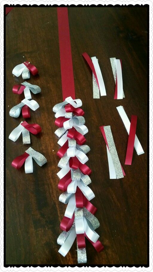 some red and white ribbons are laying on a table with other pieces of paper that have been cut out