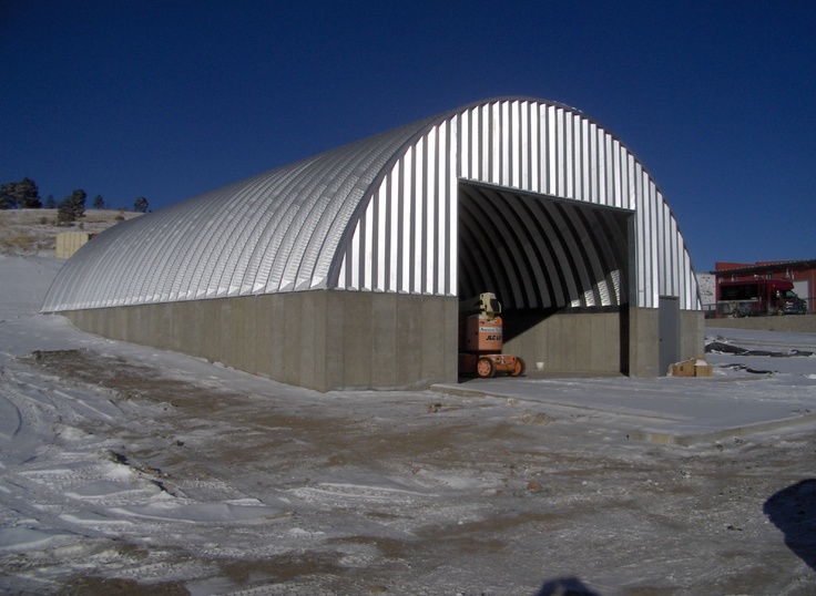 a large metal building sitting on top of snow covered ground