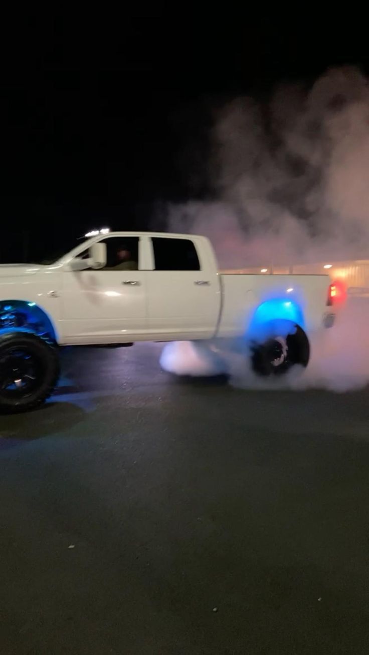 a white truck with blue lights on it's tires