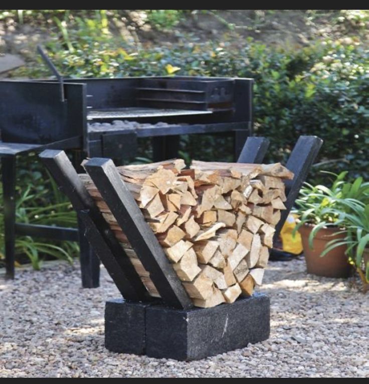 a pile of firewood sitting in front of a grill