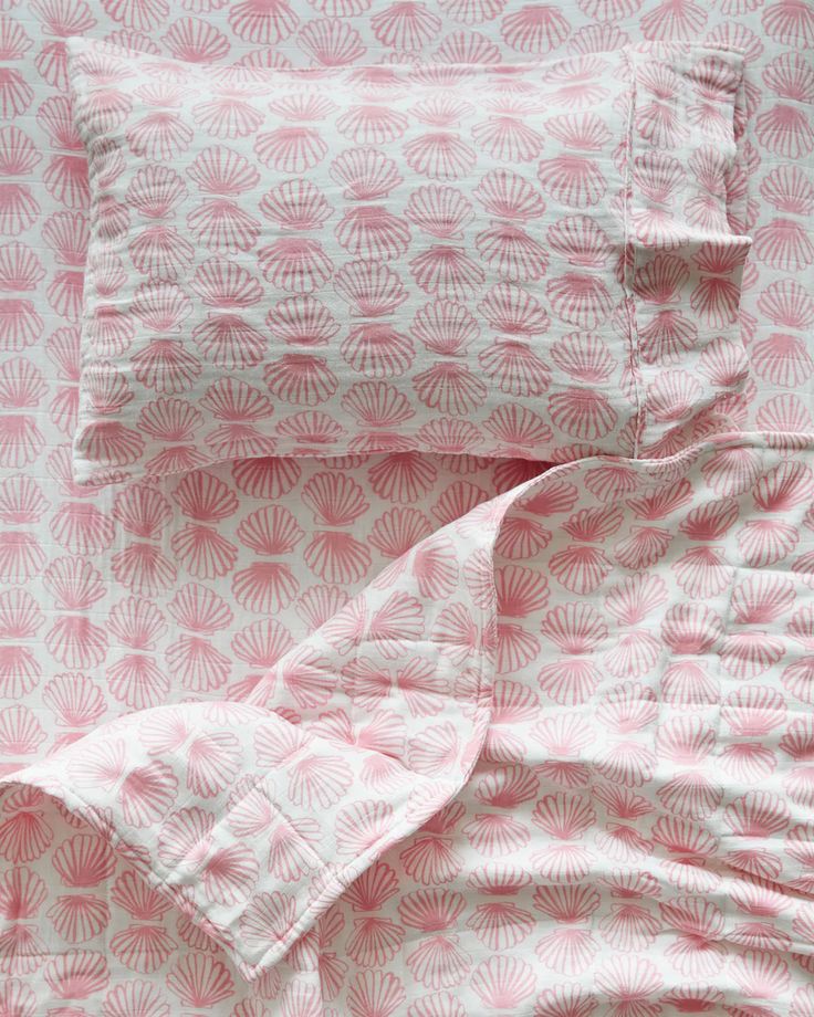 the pink and white bedding is made up with two pillows on top of each other