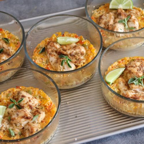 four glass dishes filled with food and garnished with limes on the side