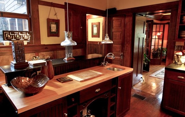 a kitchen with wood paneling and wooden floors