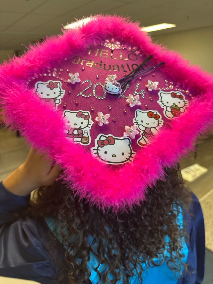 a woman with long hair wearing a pink hello kitty hat and holding her head to the side