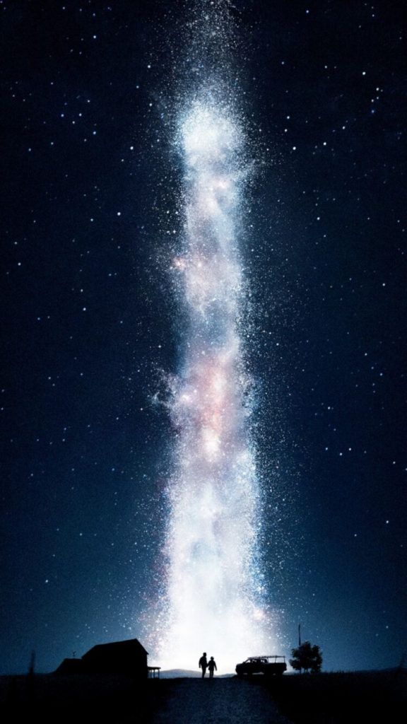 two people are standing under the stars in the night sky, looking up at the milky