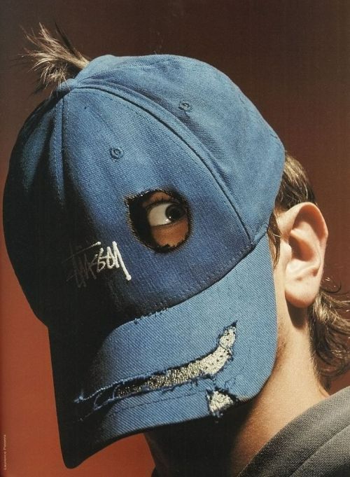 a man wearing a blue hat with holes in the front and side of his face