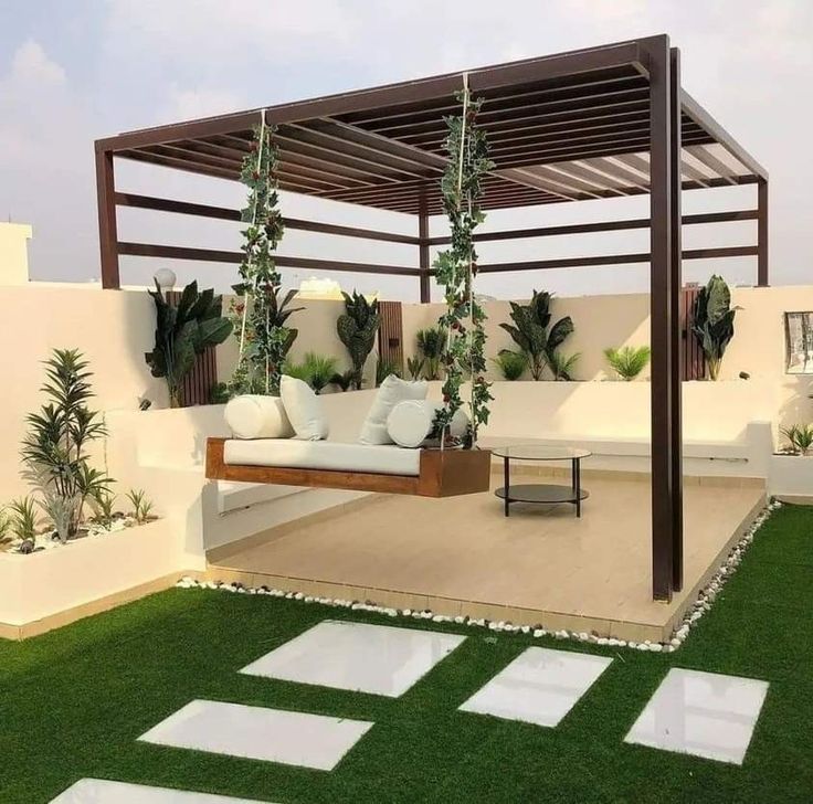 an outdoor living area with grass and plants on the roof terrace, surrounded by white tiles