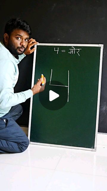 a man kneeling down in front of a blackboard with writing on it and an eraser next to him