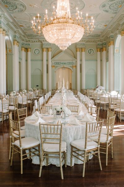 an elegant ballroom with chandelier and white linens