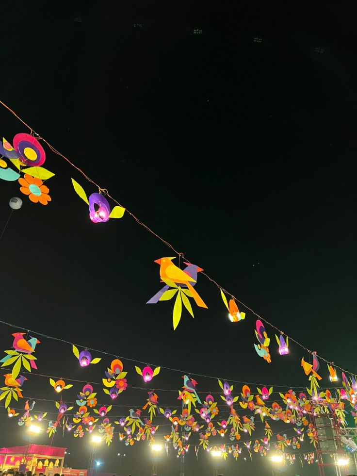 many colorful paper flowers are hanging in the air