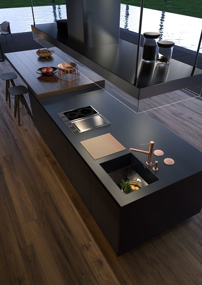 a modern kitchen with black counter tops and wooden flooring