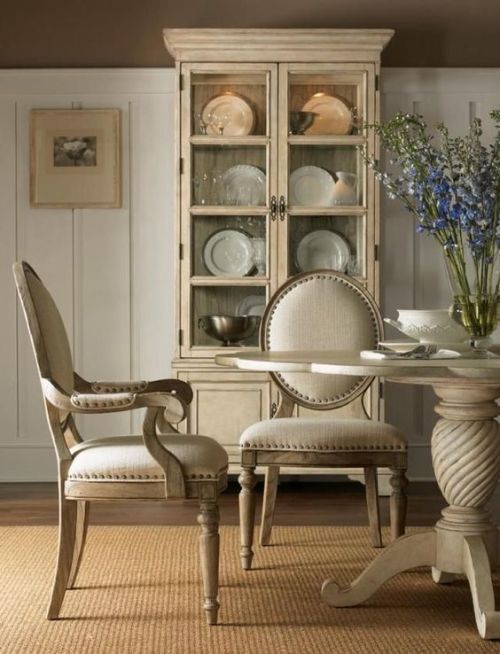 a dining room table with two chairs and a china cabinet