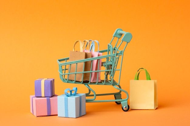 a miniature shopping cart filled with gifts on an orange background