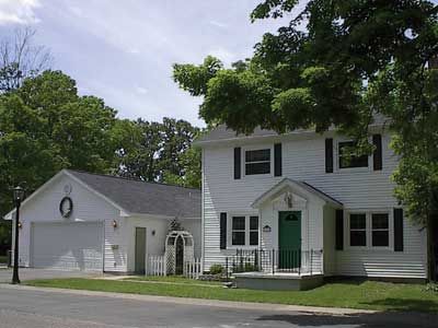 a white two story house with green front door