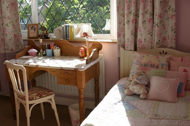 a bed room with a neatly made bed and a small desk in front of a window