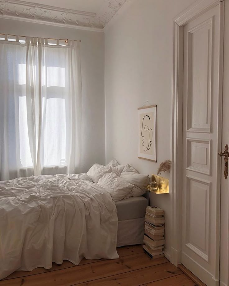 a bed room with a neatly made bed next to a window