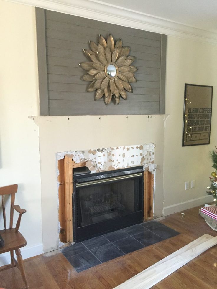 a living room with a fire place and christmas tree in the corner on the far wall