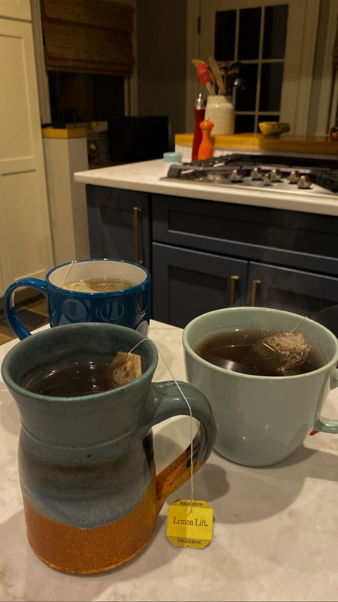 two mugs filled with liquid sitting on top of a counter