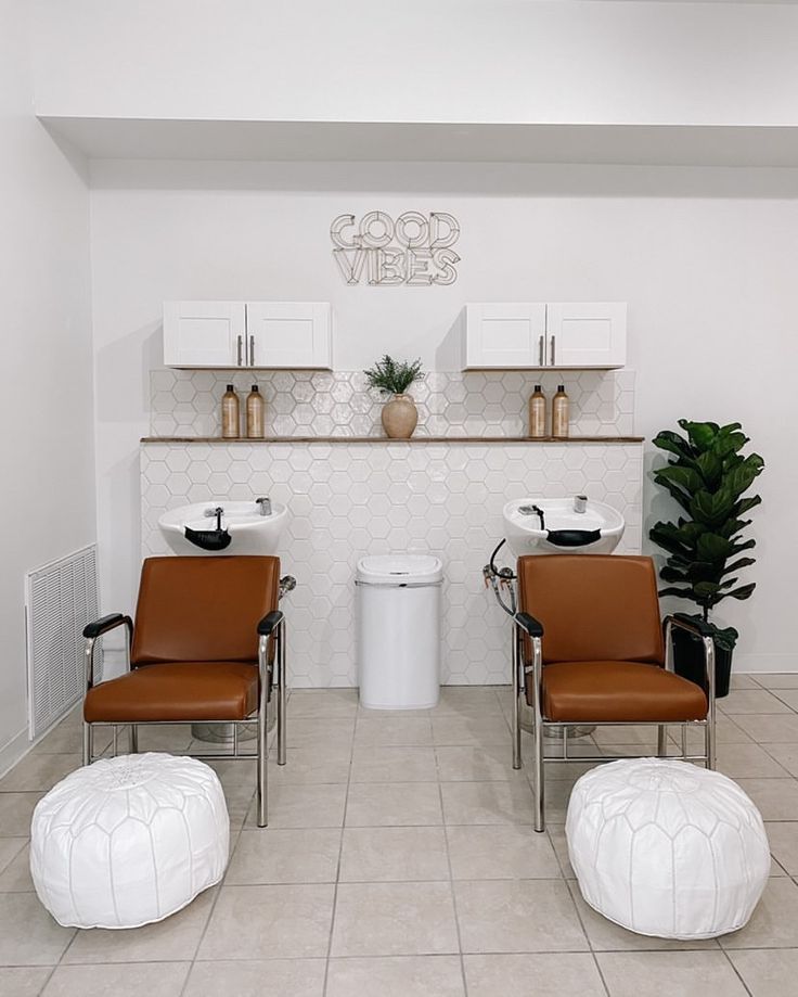 two brown chairs sitting next to each other on top of a tile floor in a room