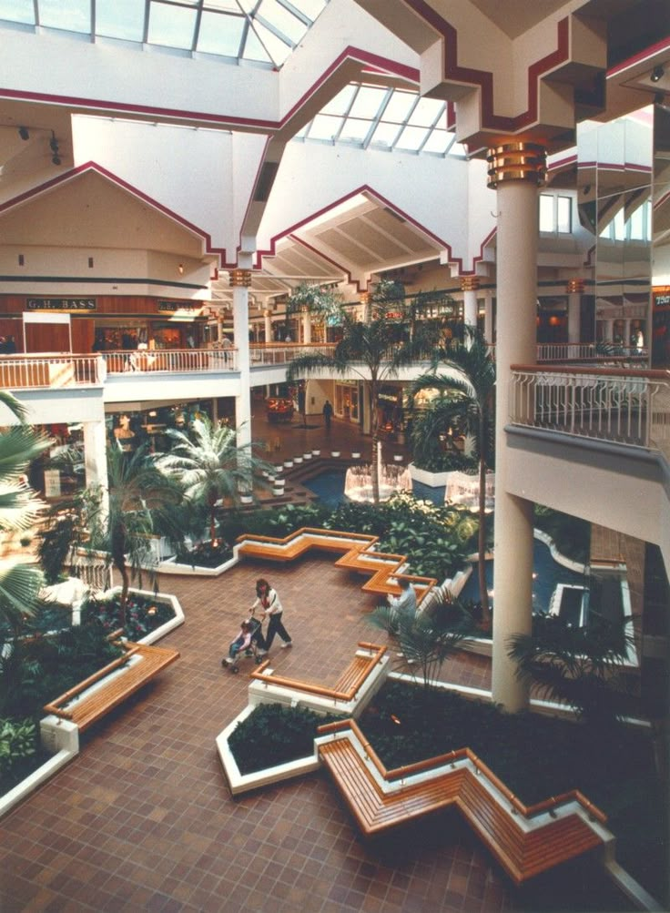 an indoor mall filled with lots of plants and people