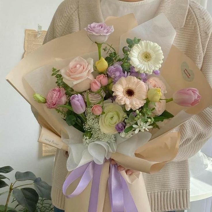 a woman holding a bouquet of flowers in her hands