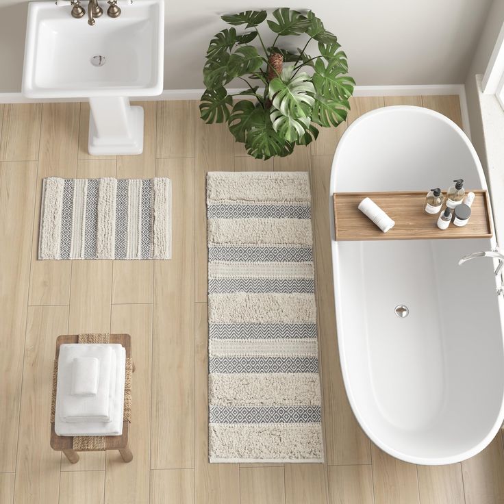 an overhead view of a bathroom with bathtub, rug and sink