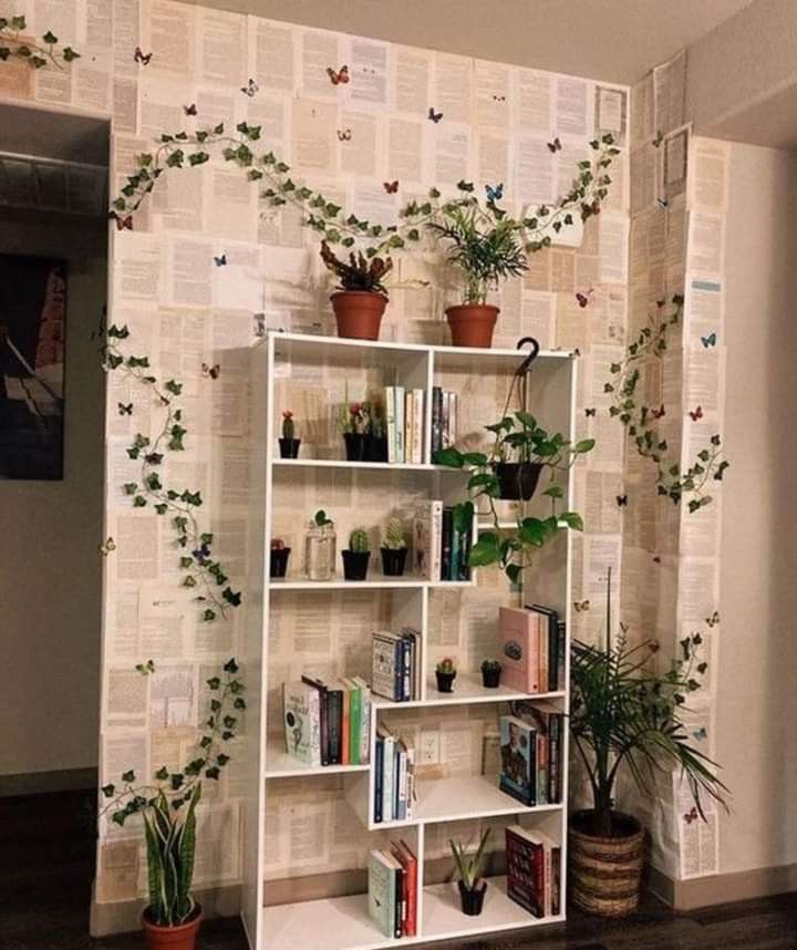 a bookshelf filled with lots of plants next to a wall