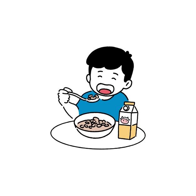 a boy sitting at a table with cereal and milk in front of him, eating