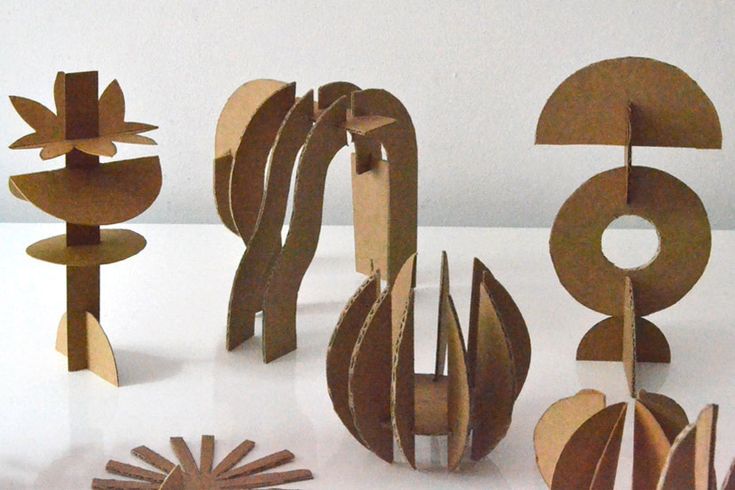 an assortment of wooden sculptures sitting on top of a white table next to each other