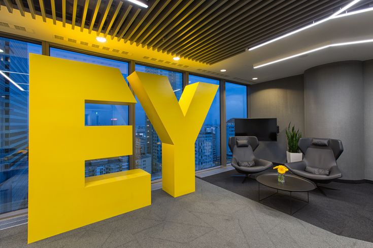 an office with large yellow letters in the middle of it and two gray chairs next to each other