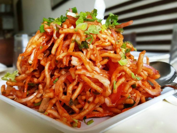 a white plate topped with lots of food on top of a table next to a fork